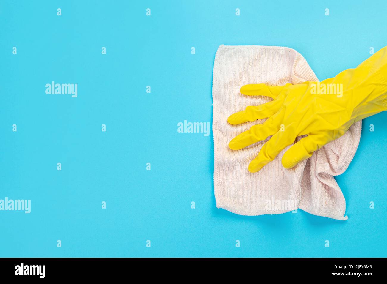 worker's hand in a yellow rubber protective glove with a pink-beige ...