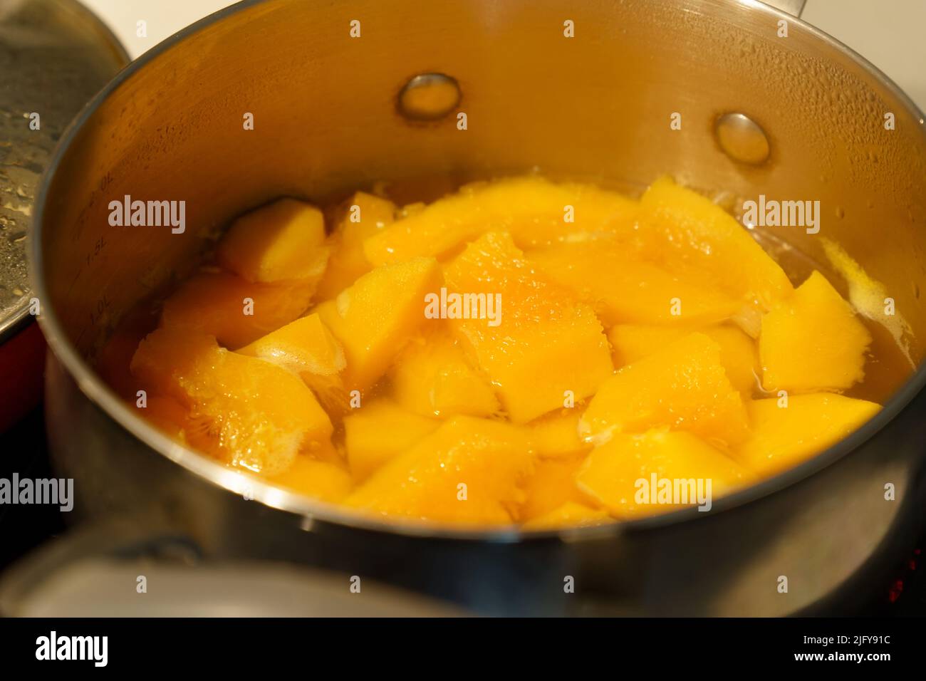 Slices, pumpkin in boiling water in a pot. Cooking healthy meal. Diet