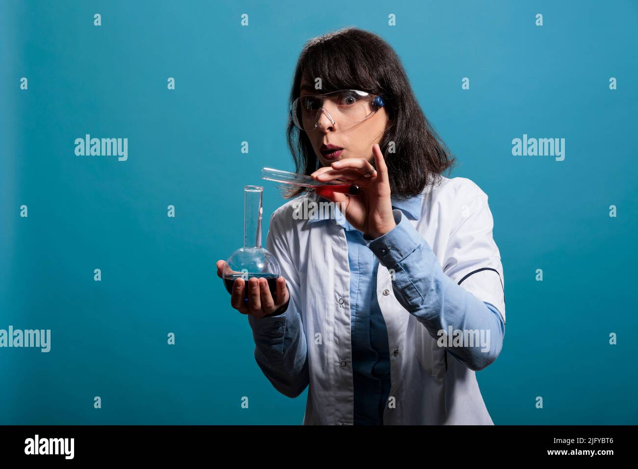 Laboratory worker expert carefully mixing liquid substances while