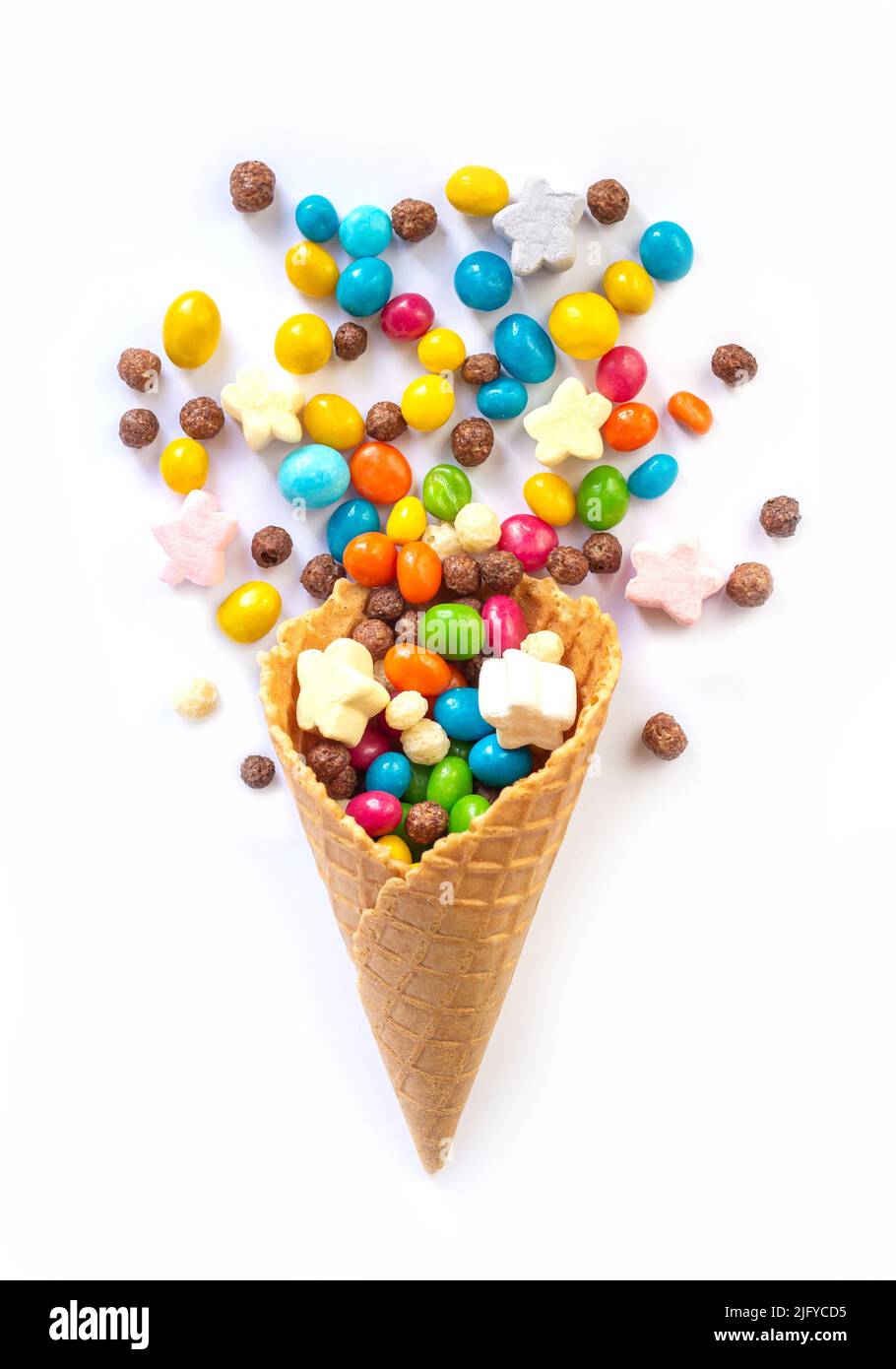 Ice cream waffle cone with different candy isolated on white background. Stock Photo