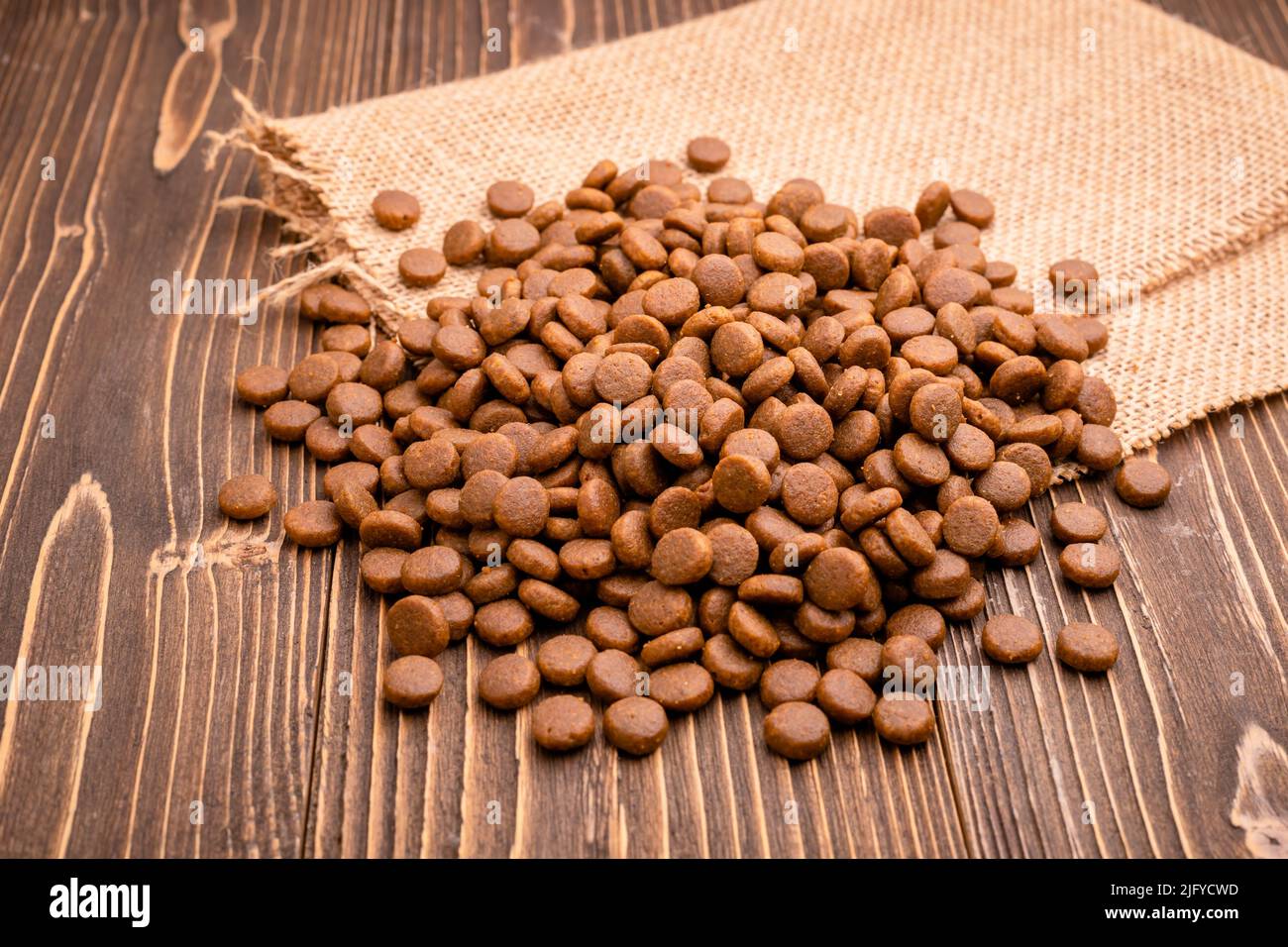 Pile of dog food on brown wooden plank background Stock Photo