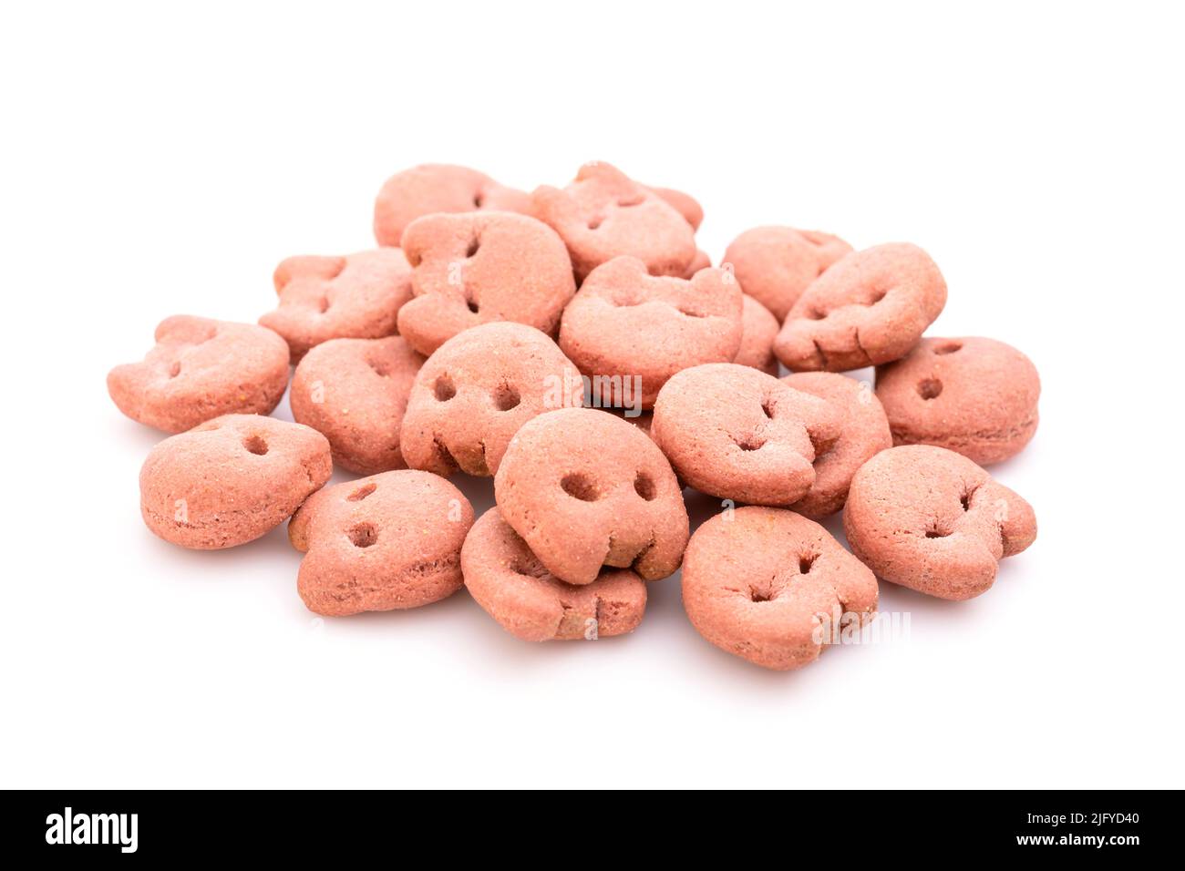 Pile of dog food (pink cookie) grilled beef taste isolated on white
