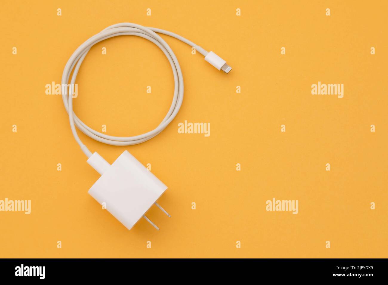 Top view new white smartphone charger on orange background with copy space for text or design Stock Photo