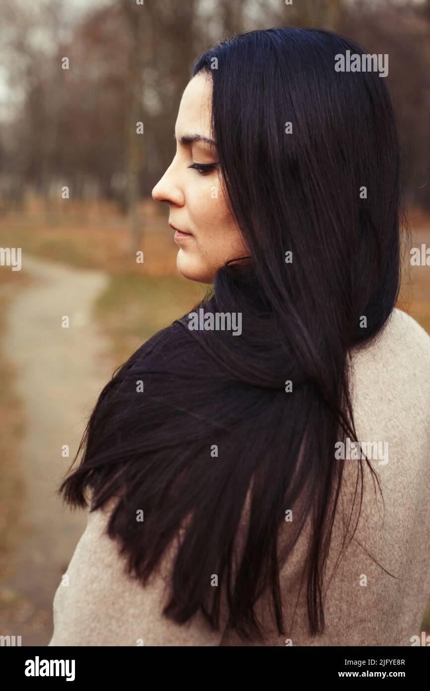 portrait of brunette woman with thick beautiful long hair close outdoor. Stock Photo