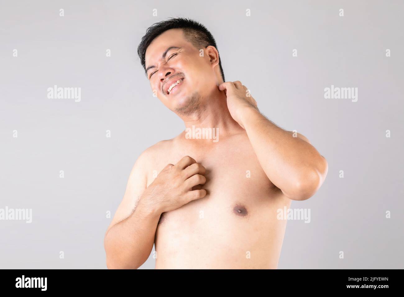 Health care or Itchy or Tinea Cruris concept : Portrait of people using hands to Scratching on his body. Studio shot on grey background Stock Photo