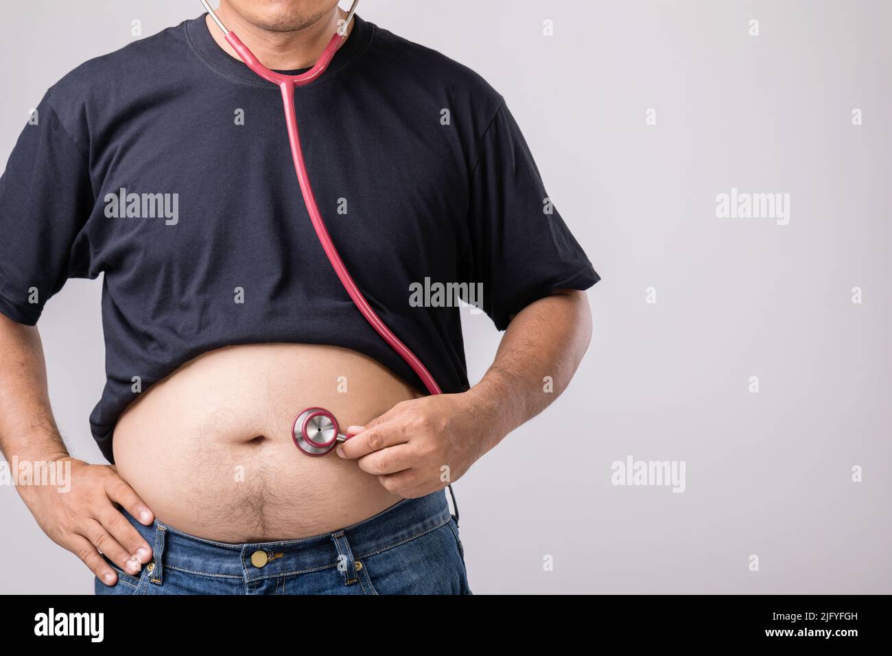 Medical Check up concept : Fat people holding red doctor stethoscope for check his health and body. Studio shot on grey background Stock Photo