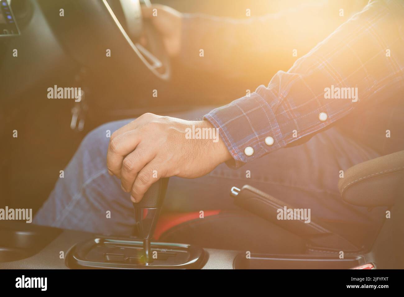 Car driving concept Close up driver hand on automatic gear inside the