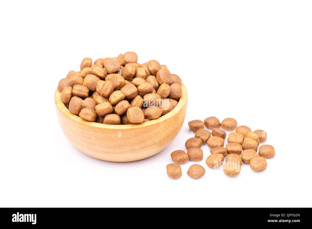Pile of dog food in wooden bowl isolated on white background Stock Photo