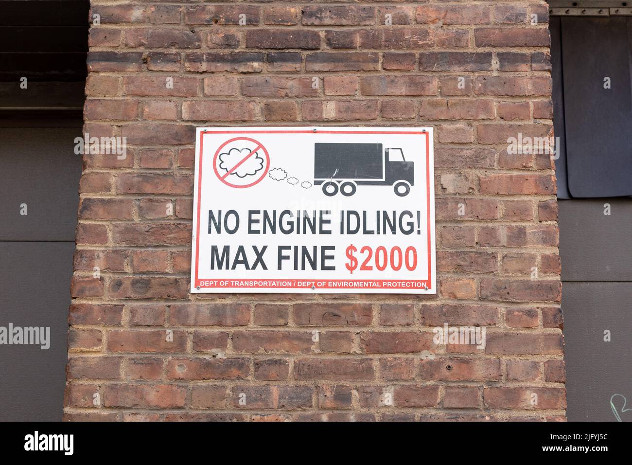 A No Engine Idling Sign on a brick wall to reduce pollution Stock Photo