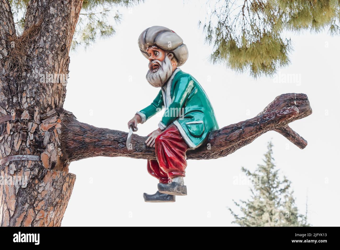 30 May 2022, Antalya, Turkey: Fairy tale character Sultan sawing a branch on which he sits. Funny and metaphoric plot Stock Photo