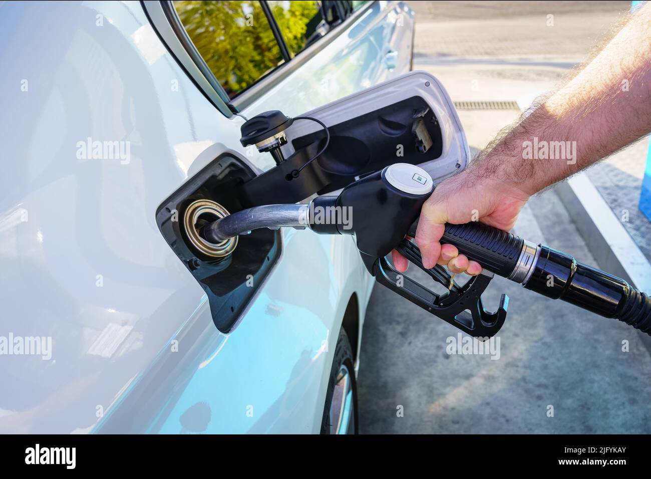 Hand of a man filling the fuel tank of the car at a gas station. Stock Photo