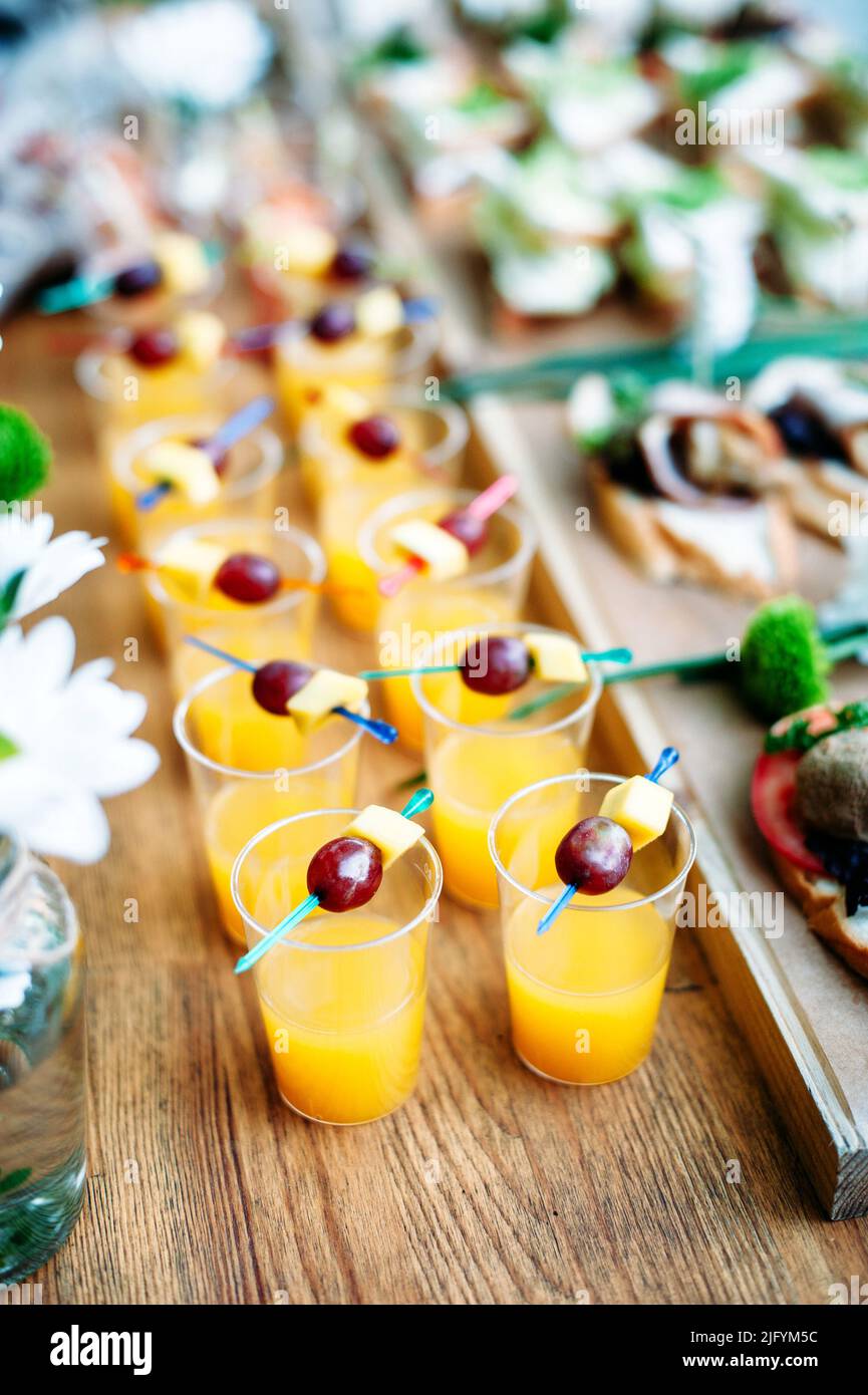 Beautiful line of different alcohol and non-alcohol cocktails. Vertical photo. Catering table for party and banquet. Stock Photo