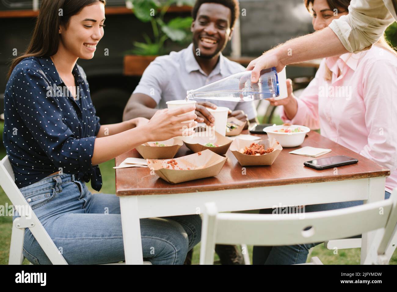 Crop waiter serving water for client Stock Photo Alamy