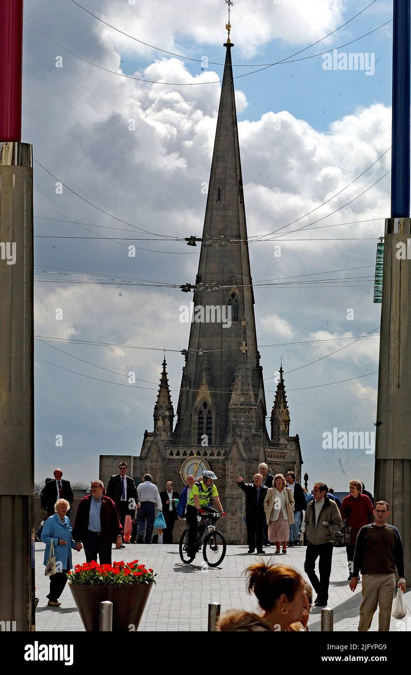 The tower and spire of the 18th century church of St Martin’s in the Birmingham city centre appears to erupt from the end of the main shopping High Street as pedestrians casually walk by.  The church is a Grade II listed building on its original 12th century site. The medieval tower and spire had been refaced and embellished by Philip Hardwick between 1853-5.  This was carefully demolished and rebuilt by the architect Julius Chatwin who slightly enlarged the medieval plans part of his intentions to rebuild the whole of the church in 1873 much of which dated from the Georgian period. Stock Photo