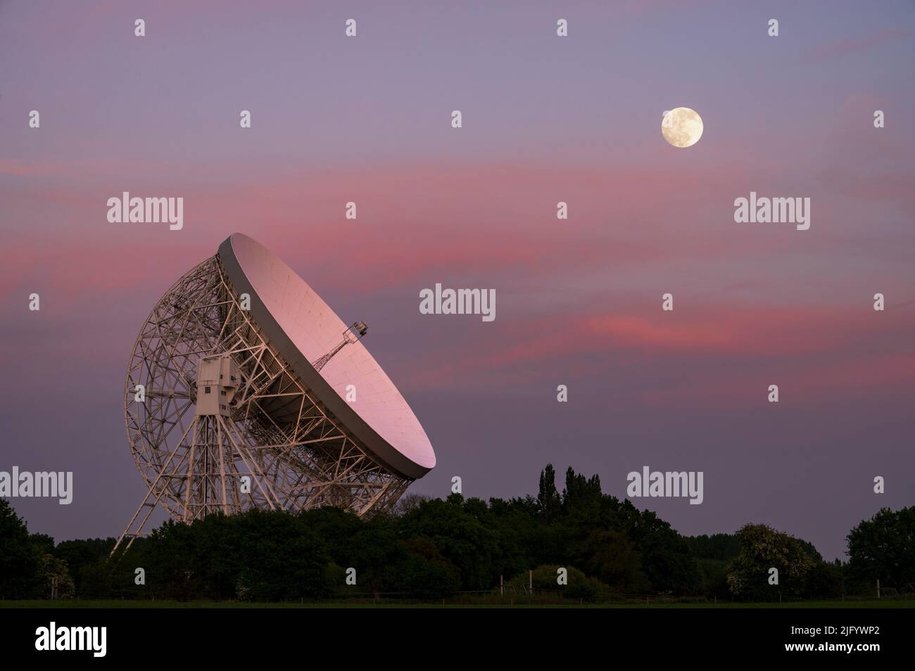 The Lovell Mark I Giant Radio Telescope at night with perfect alignment with the full moon, Jodrell Bank, Cheshire, England, United Kingdom, Europe Stock Photo