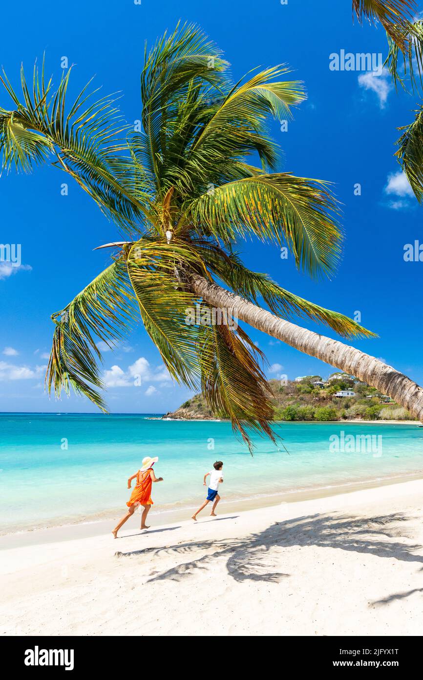 Woman and little boy having fun running on a palm fringed beach, Antigua, West Indies, Caribbean, Central America Stock Photo