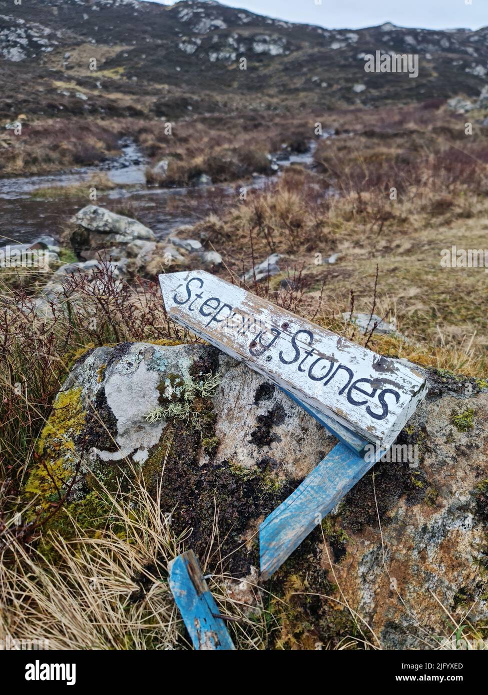 A vertical view of a broken sign mentioning stepping stones in the ...