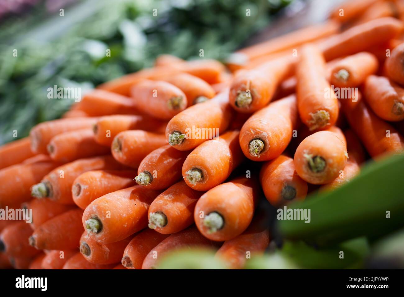 Selective focus on carrot. Sale of fresh raw vegetable in market stall. Stock Photo