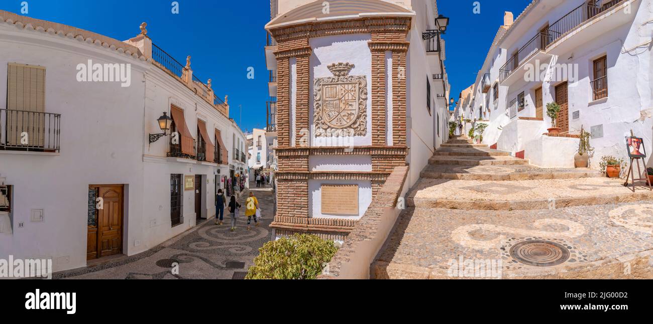 View of whitewashed houses and shoppers on narrow street, Frigiliana, Malaga Province, Andalucia, Spain, Mediterranean, Europe Stock Photo