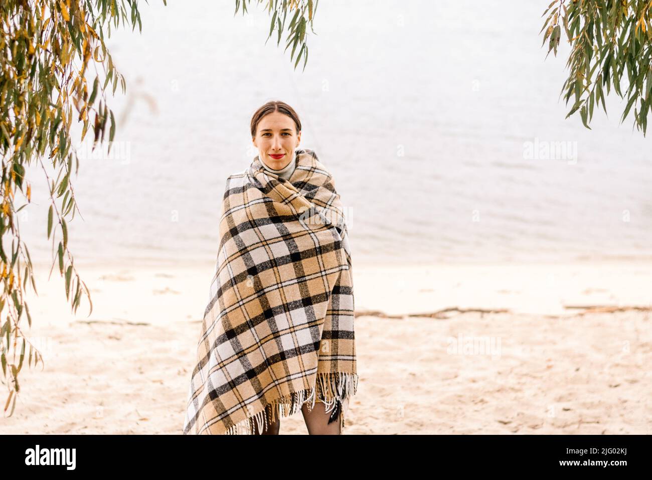Happy family under a blanket on the beach hires stock photography and