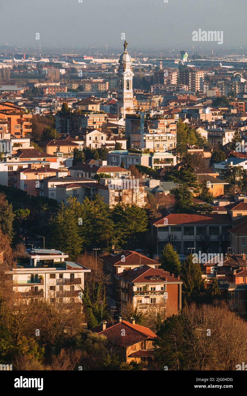 the city of Bergamo, its historic center and the hills, with the lights of the sunset, at the end of a winter day - February 2022. Stock Photo