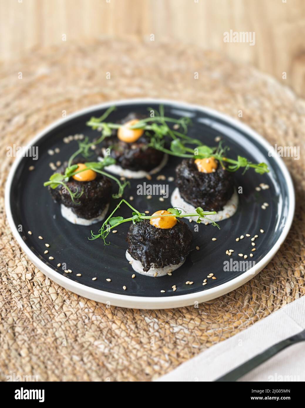 Croquettes in tempura with squid ink stuffed with spanish ratatouille