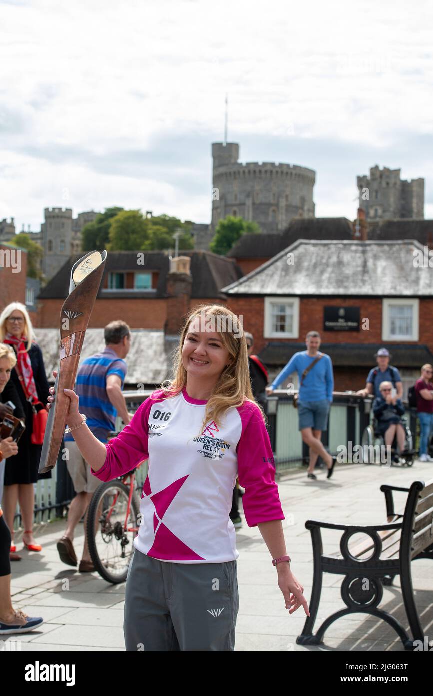 Eton, Windsor, Berkshire, UK. 6th July, 2022. Baton carrier Jemma Wood stands on Windsor Bridge with views of Windsor Castle. Jemma was nominated by PwC to carry the baton. Jemma has Cystic Fibrosis and has spent 740 days of her life in hospital, 530 days devoted to nebulisers/physio and takes 720 tablets per month. Despite this, Jemma has achieved honorary life membership to the University of London gymnastics team and raised over £300,000 for the Cystic Fibrosis Trust. Credit: Maureen McLean/Alamy Live News Stock Photo