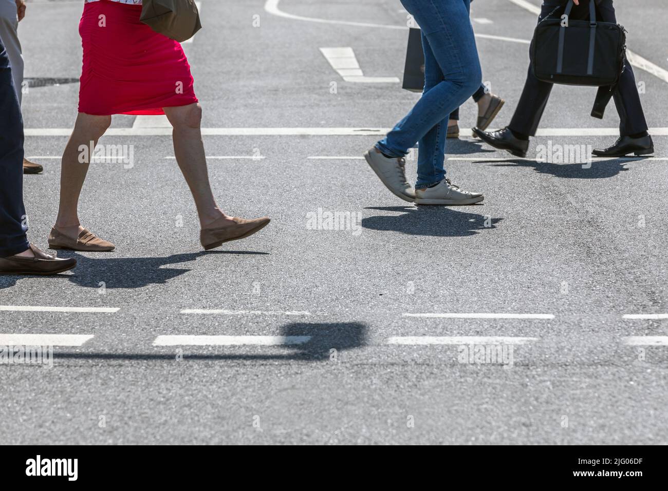 pedestrians cross the street at the traffic light Stock Photo