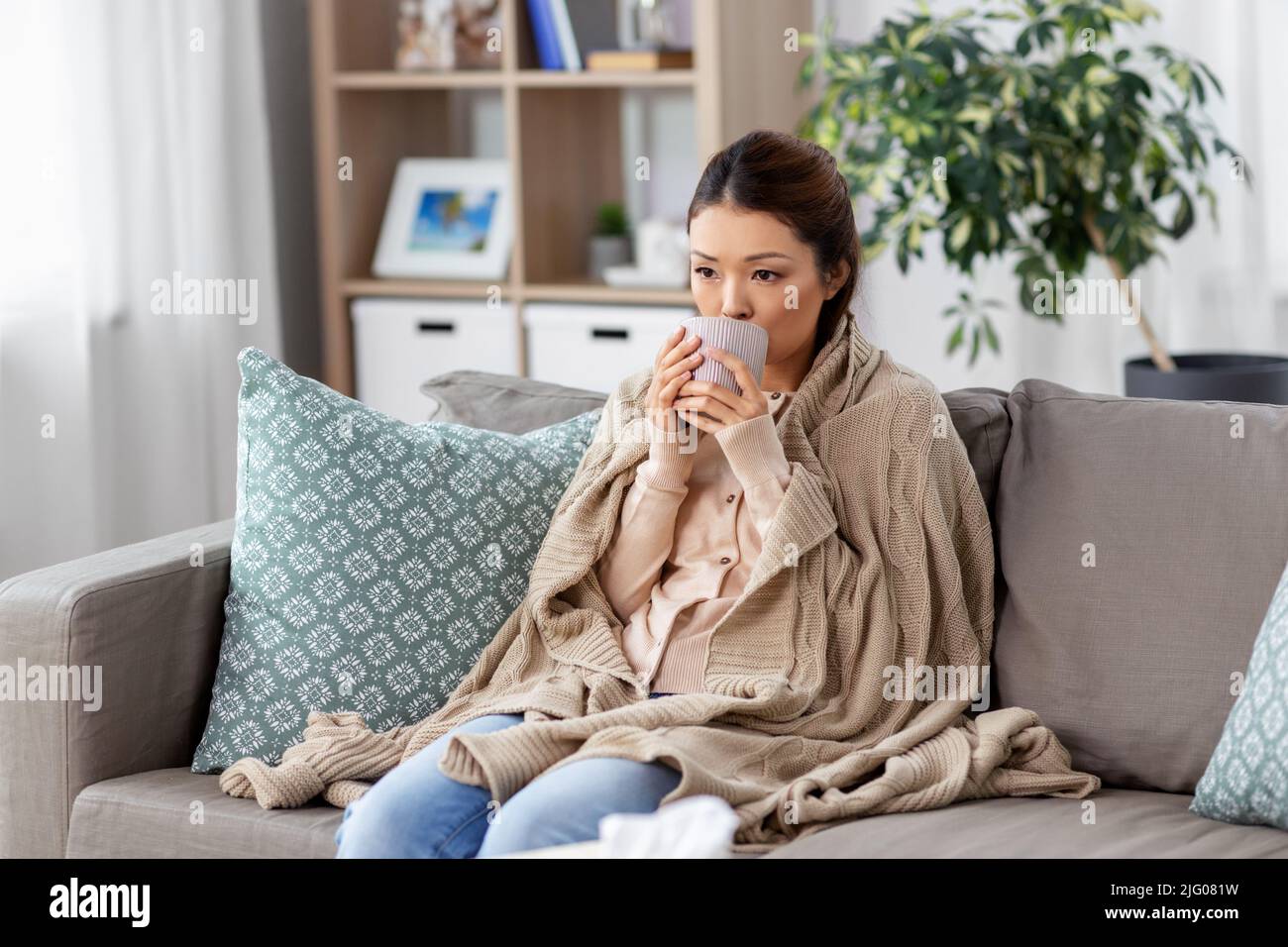 sad sick asian woman drinking hot tea at home Stock Photo Alamy