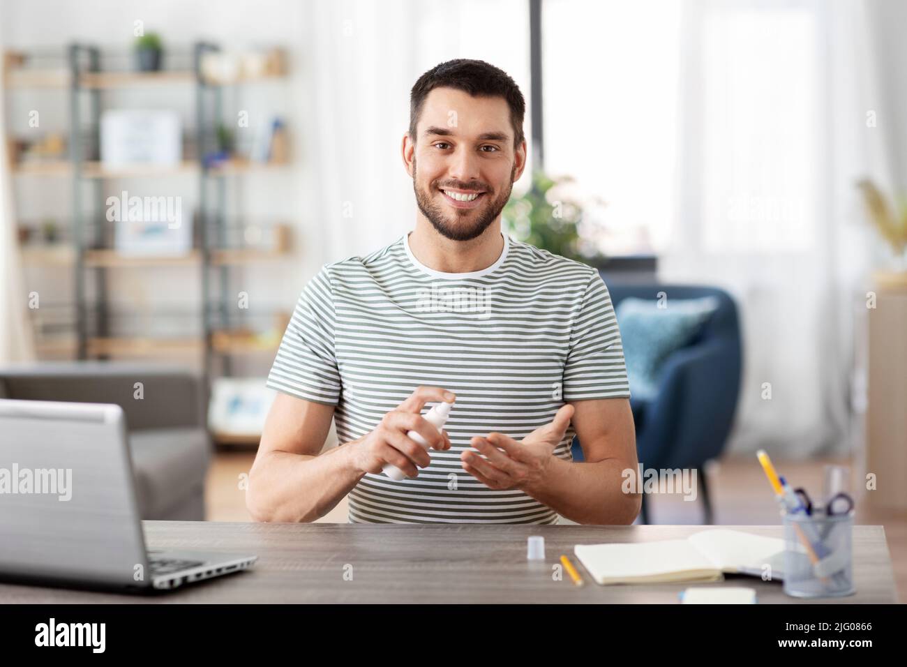 man using hand sanitizer at home office Stock Photo