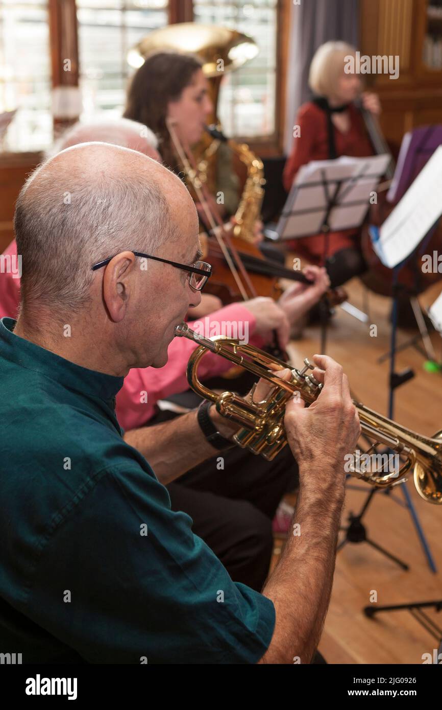 Trumpeter playing a rehearsal piece with the CoMA (Contemporary Music for All) Sussex group in West Dean College, West Sussex, UK Stock Photo