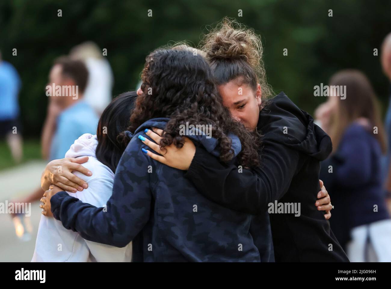 Highland Park, USA. 5th July, 2022. Teens comfort each other by hugging after a prayer vigil in Highland Park, suburb of Chicago, Illinois, the United States, July 5, 2022. People held mourning services for a mass shooting during an Independence Day parade in downtown Highland Park on July 4. The death toll of the mass shooting has risen to seven, as police updated the number of people wounded to 46. Credit: Joel Lerner/Xinhua/Alamy Live News Stock Photo