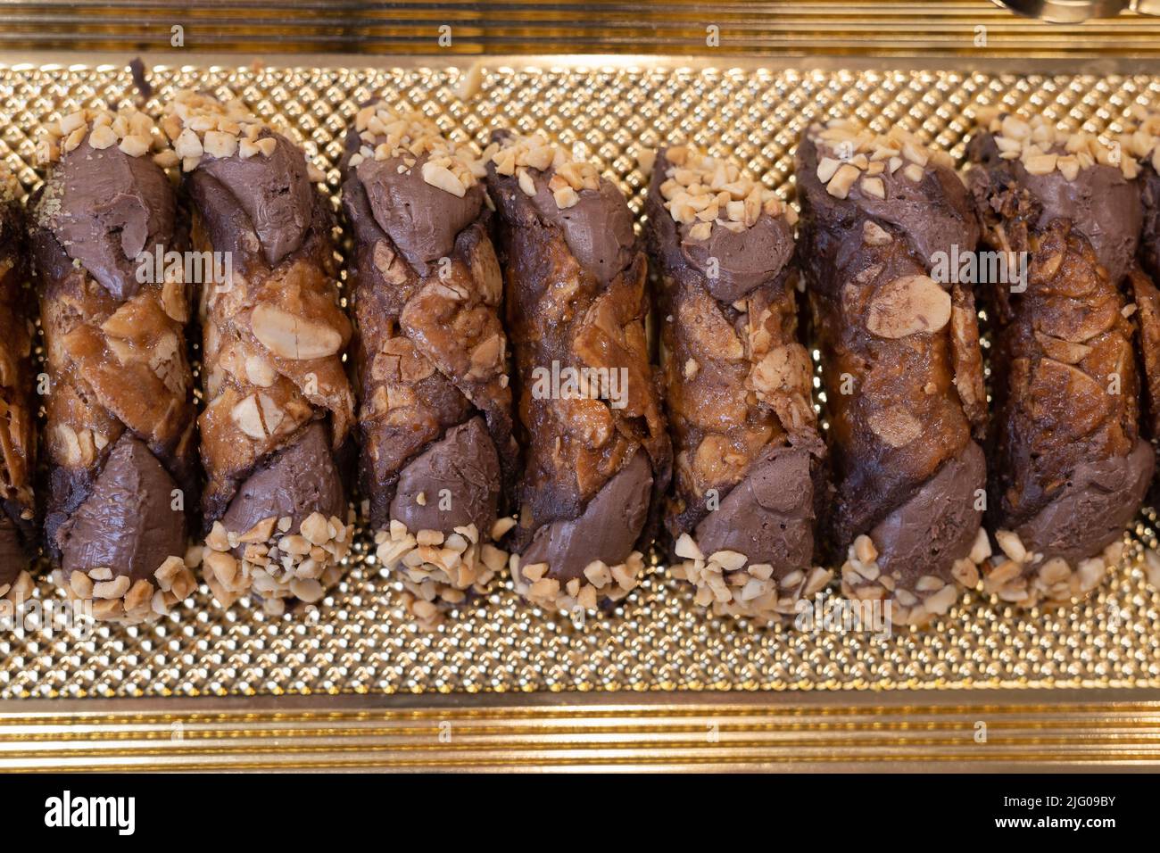 Italian Sweet Dessert, Traditional Sicilian Cannoli with Nuts and Chocolate Cream seen from Above. Stock Photo