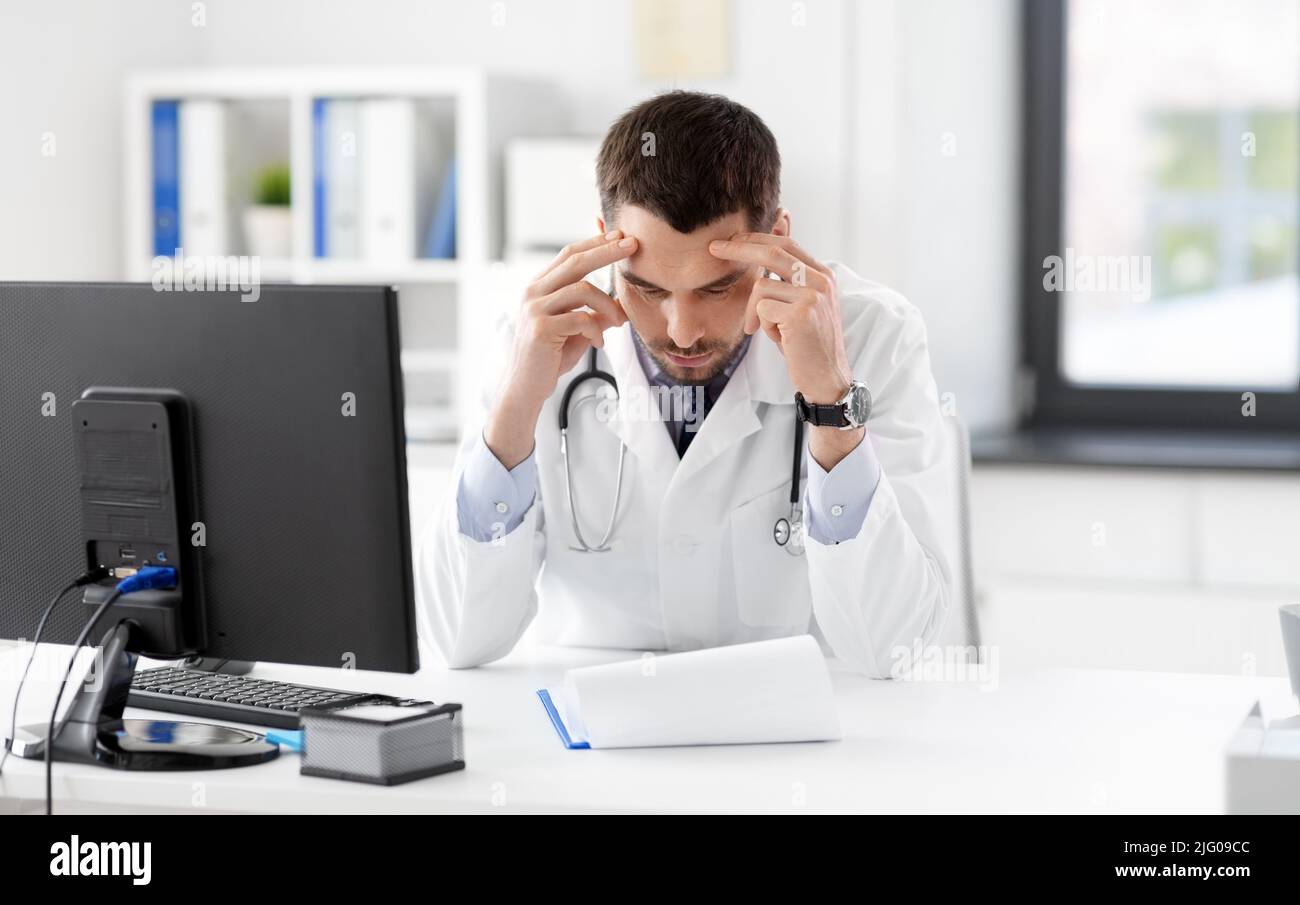 stressed male doctor with clipboard at hospital Stock Photo - Alamy