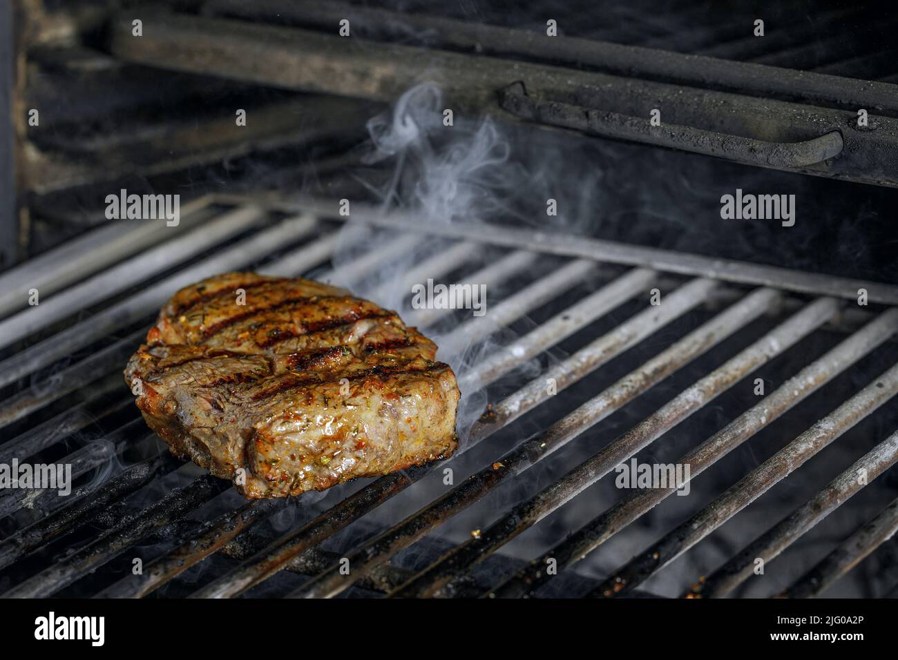 roasted meat beef steak grilling on rack charcoal stove with smoke on