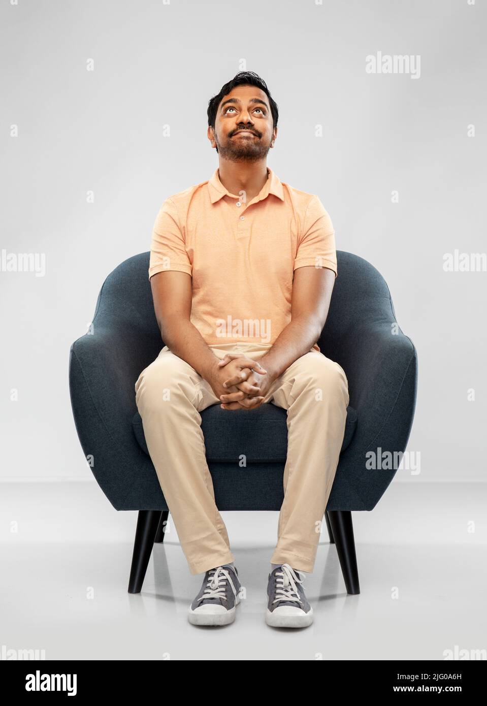 happy smiling young indian man sitting in chair Stock Photo - Alamy