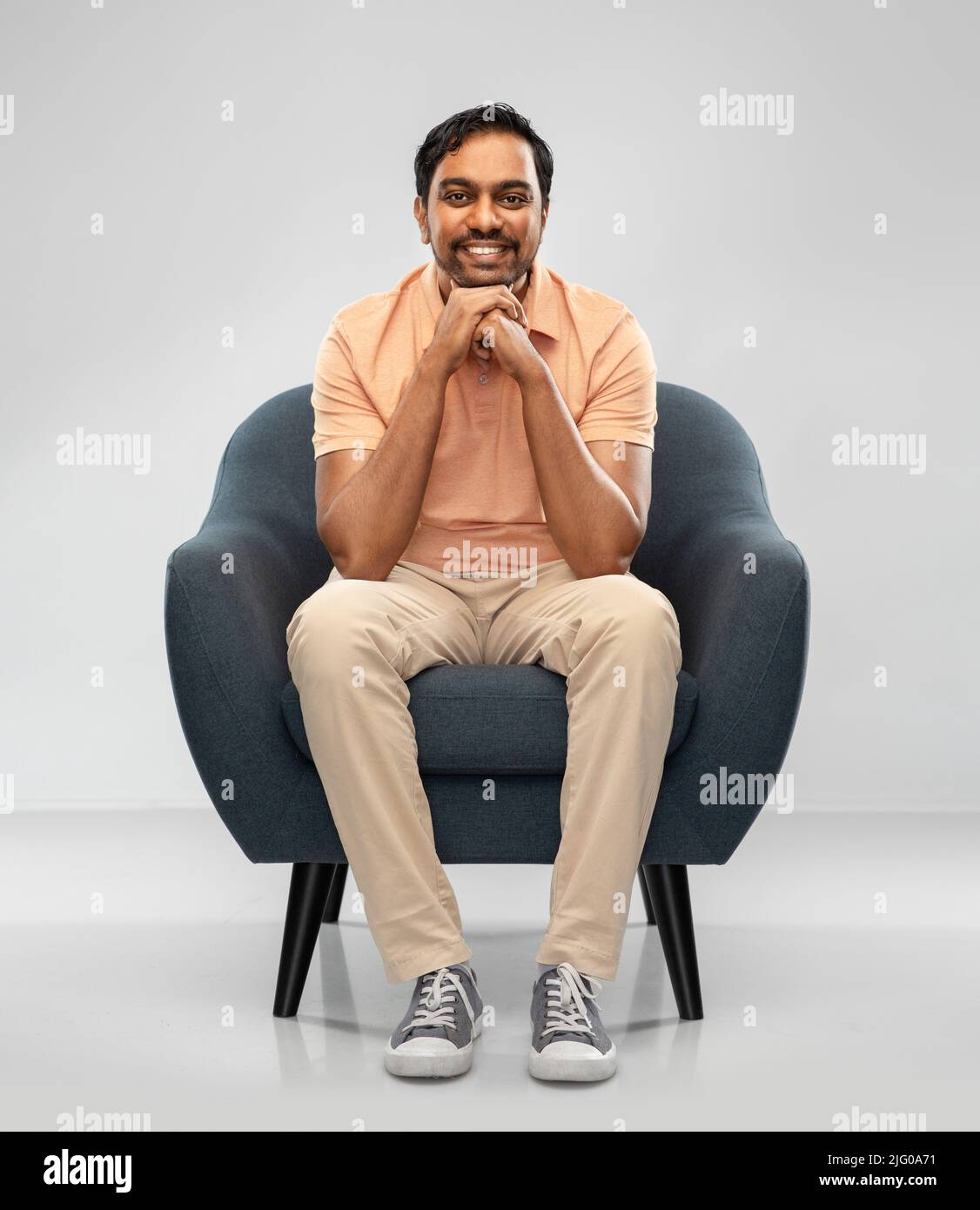 happy smiling young indian man sitting in chair Stock Photo - Alamy