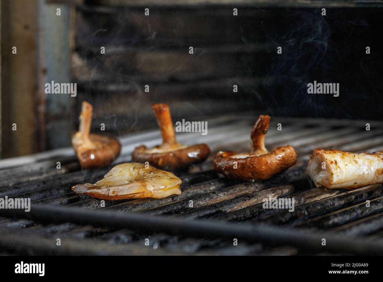 Process of grilling seafood on a barbecue grill over hot coal. Seafood recipes Stock Photo