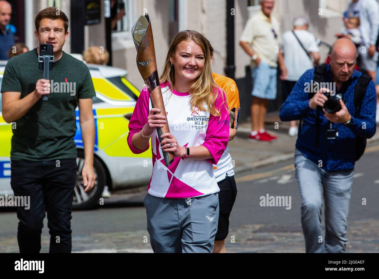 Windsor and Eton, UK. 6th July, 2022. Batonbearer Jemma Wood carries the Queen's Baton along Eton High Street towards Windsor Bridge. The Queen's Baton Relay is currently on a 25-day tour of the English regions en route to the Commonwealth Games. Credit: Mark Kerrison/Alamy Live News Stock Photo