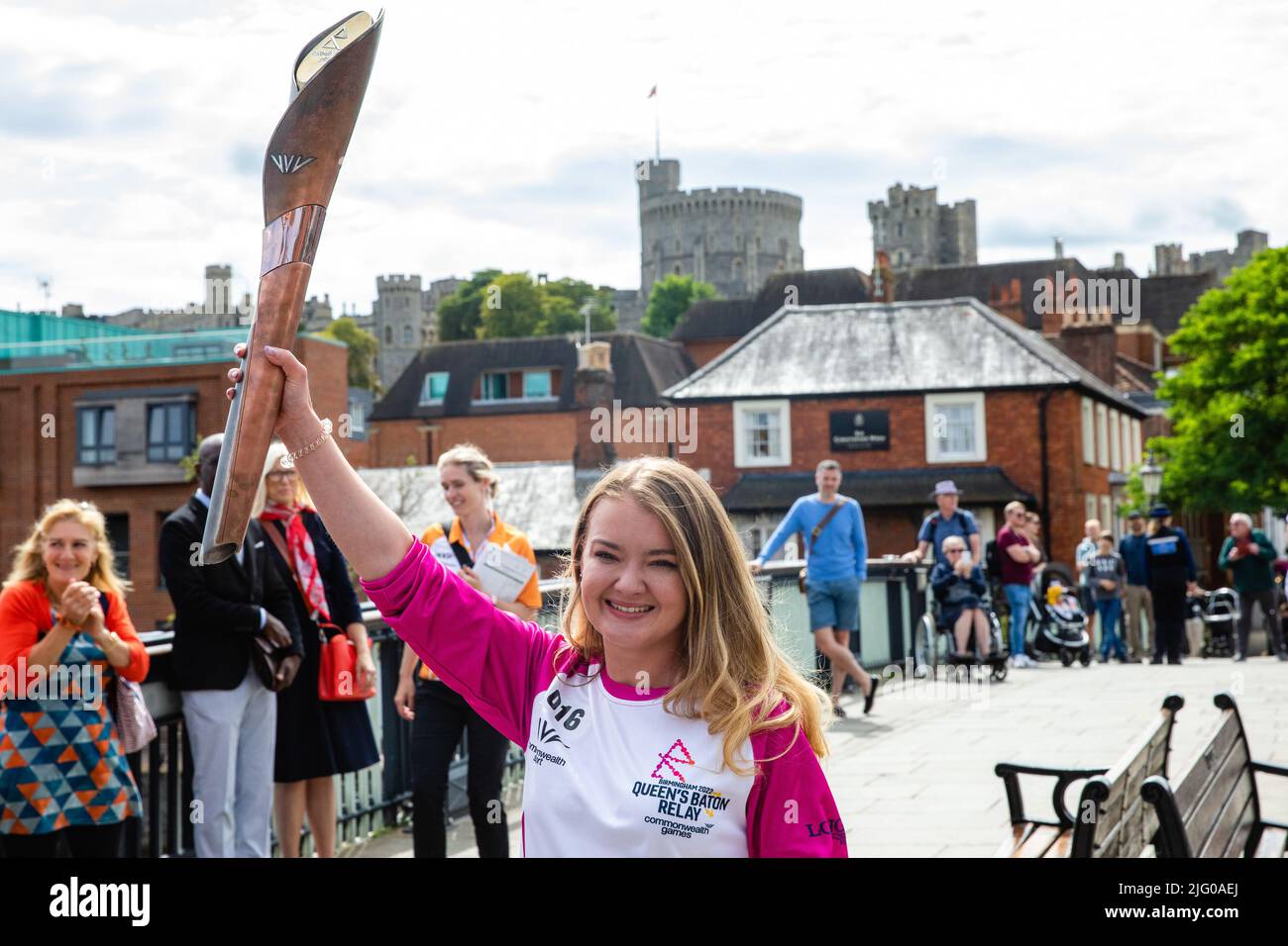 Windsor and Eton, UK. 6th July, 2022. Batonbearer Jemma Wood holds aloft the Queen's Baton on Windsor Bridge during the Queen's Baton Relay. The Queen's Baton is currently on a 25-day tour of the English regions en route to the Commonwealth Games. Credit: Mark Kerrison/Alamy Live News Stock Photo