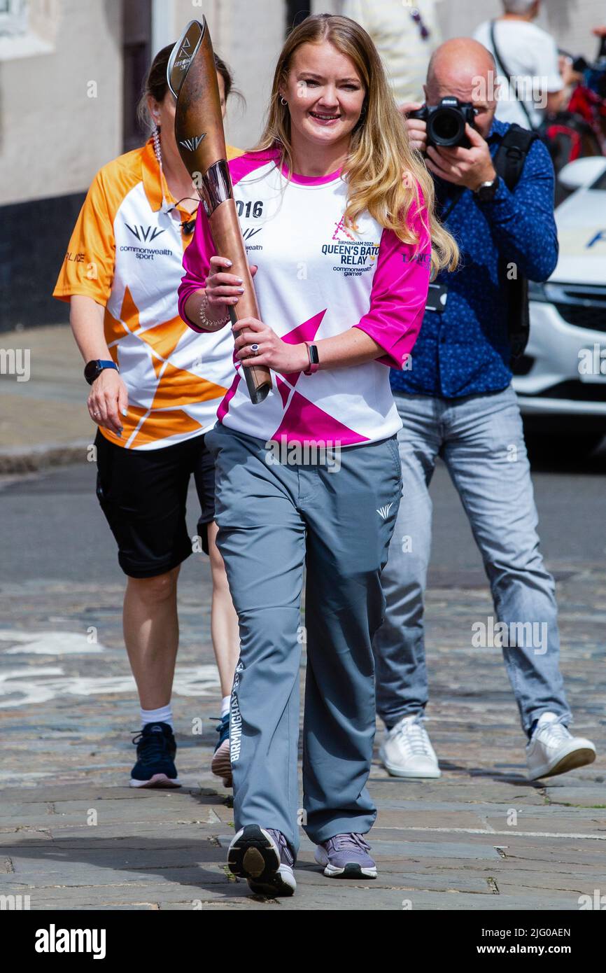 Windsor and Eton, UK. 6th July, 2022. Batonbearer Jemma Wood carries the Queen's Baton along Eton High Street towards Windsor Bridge. The Queen's Baton Relay is currently on a 25-day tour of the English regions en route to the Commonwealth Games. Credit: Mark Kerrison/Alamy Live News Stock Photo