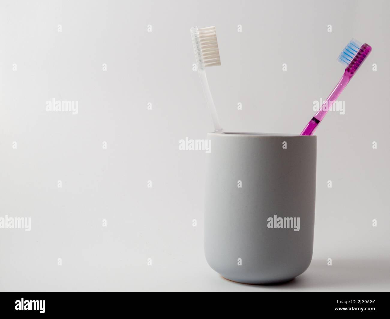 Toothbrushes in a glass with copy space on a white background Stock ...