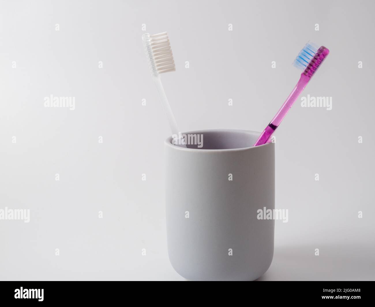 Toothbrushes in a glass with copy space on a white background Stock ...