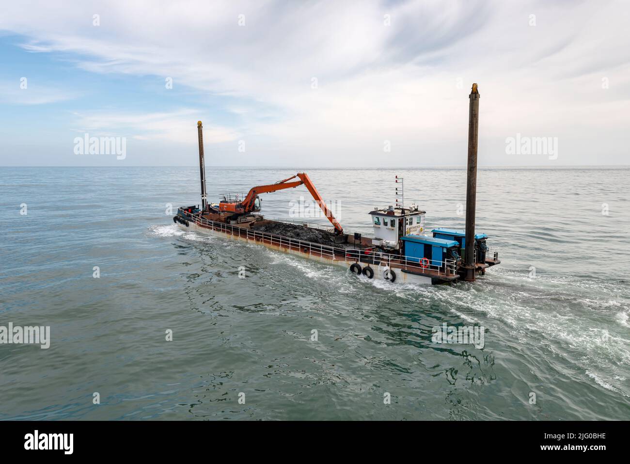 The Whitby harbour dredger heading out to sea. Stock Photo