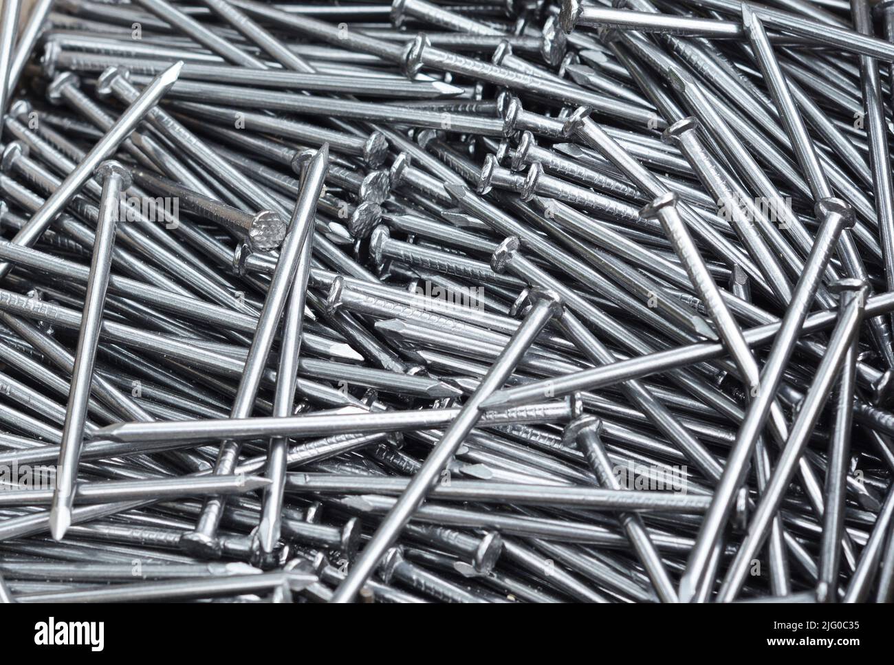 Pile of grey iron nails. Texture nails folded in one pile Stock Photo