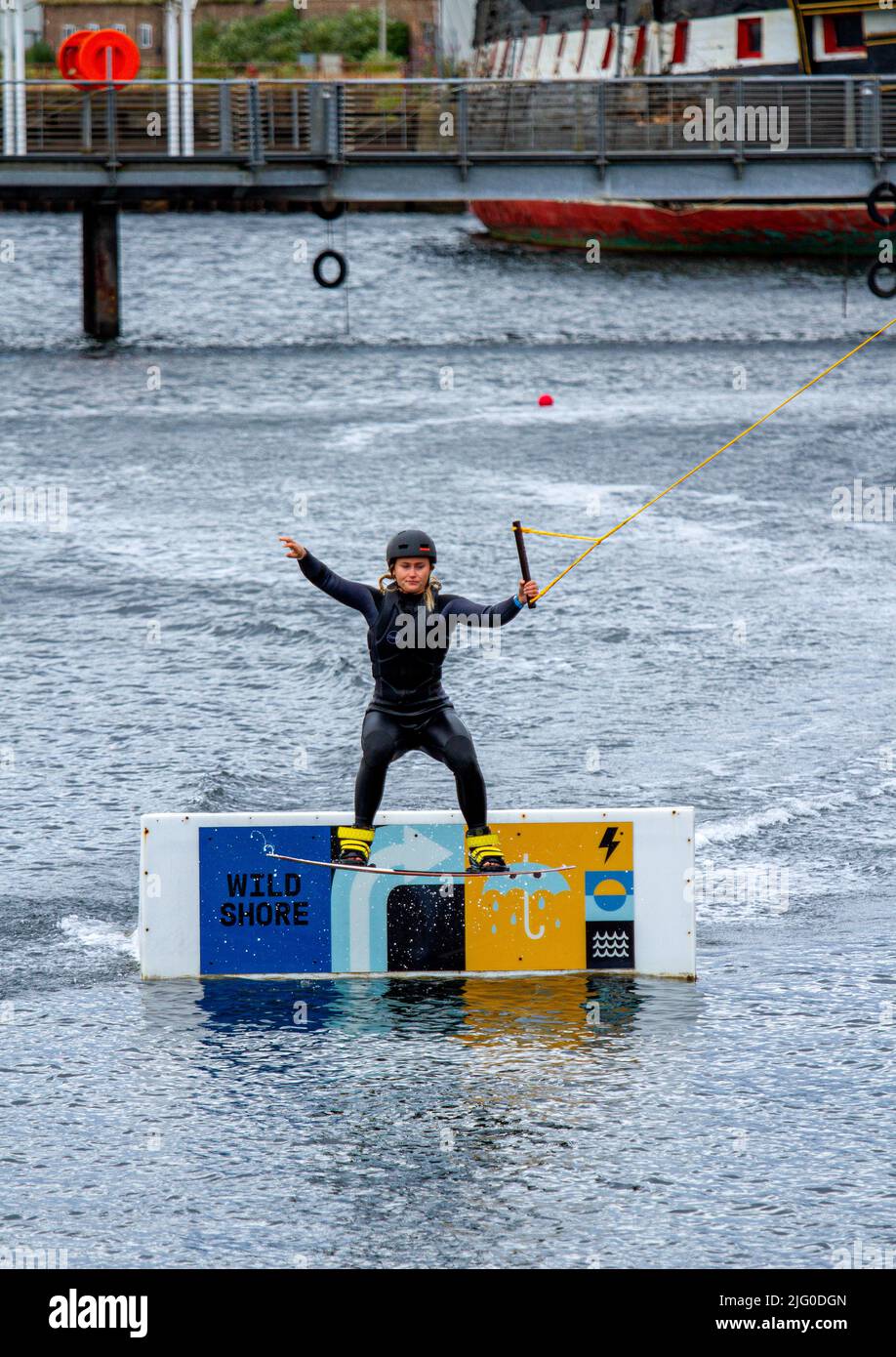 Dundee, Tayside, Scotland, UK. 6th July, 2022. UK Weather: A cloudy day with cool westerly winds, temperatures reaching 18°C in North East Scotland. Wakeboarders from Wild Shore Water sports activities enjoy a day wakeboarding on a rail at Dundee's City Quay's West Victoria Dock. Credit: Dundee Photographics/Alamy Live News Stock Photo