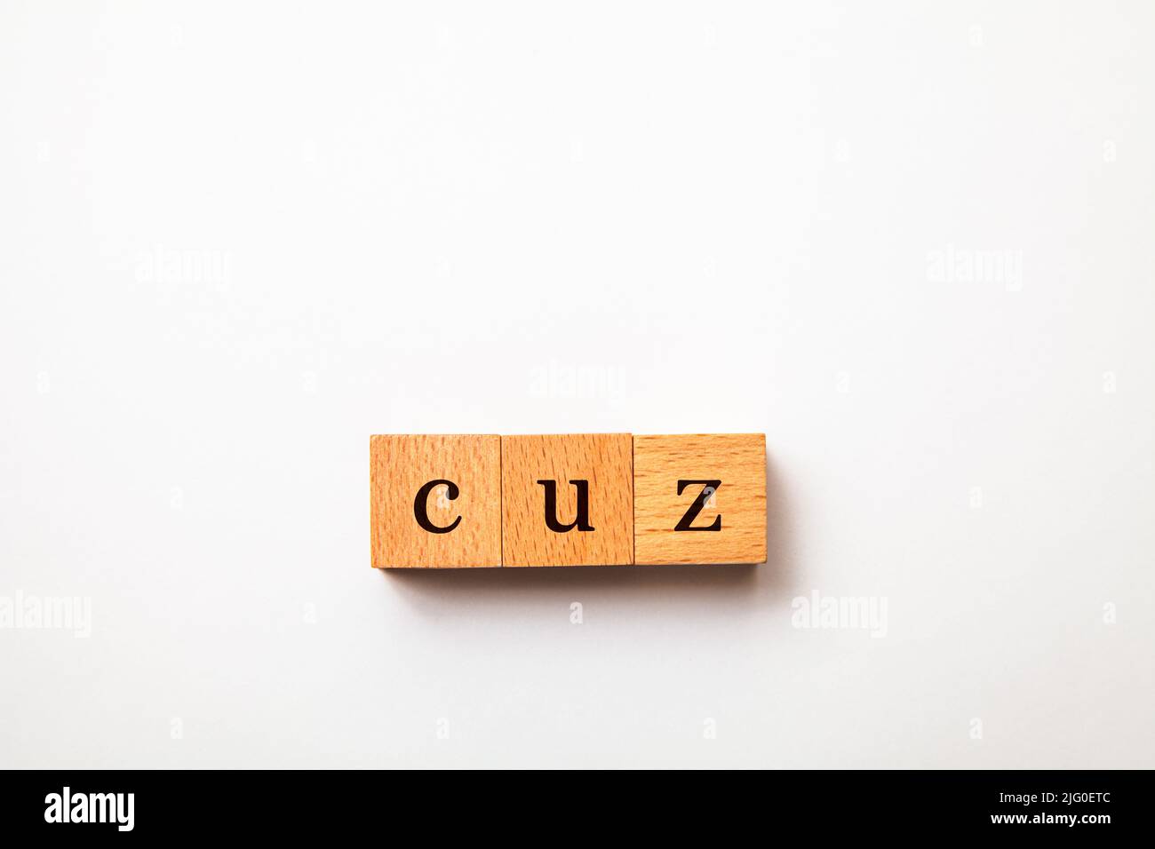 cuz character. because. cause. Written on three wooden blocks. Black letters. White background. Stock Photo