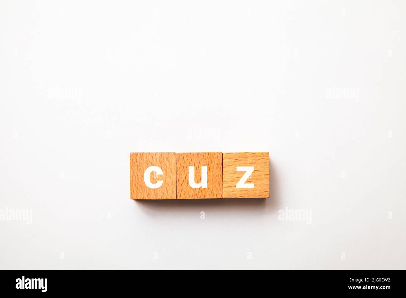 cuz character. because. cause. Written on three wooden blocks. White letters. White background. Stock Photo