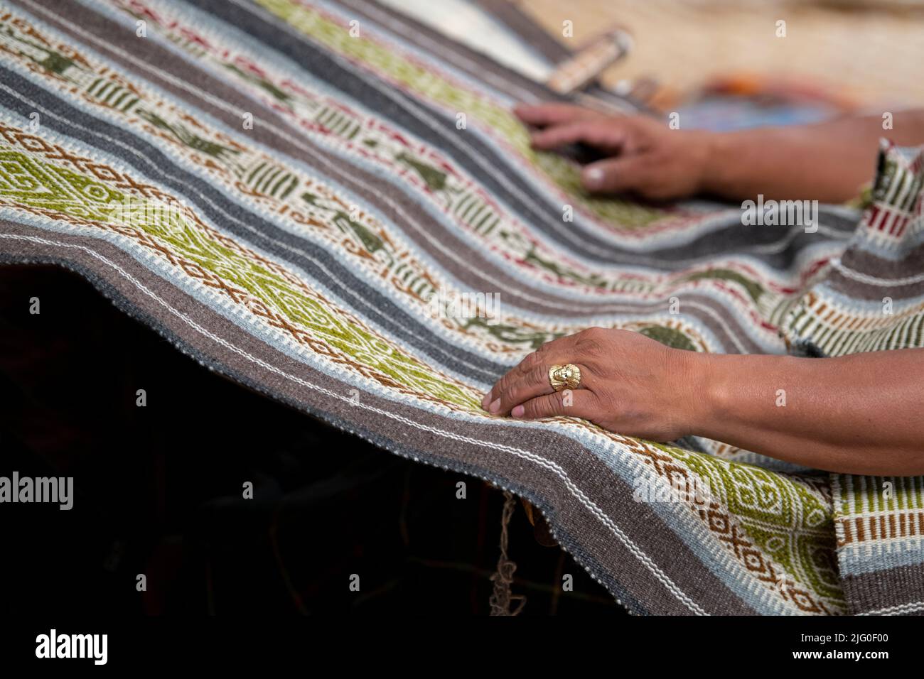Ecuador, Quito, Paguche. Tahuantinsuyo Weaving Workshop. Traditional 'back strap' weaving demonstration. Hand close up. Stock Photo