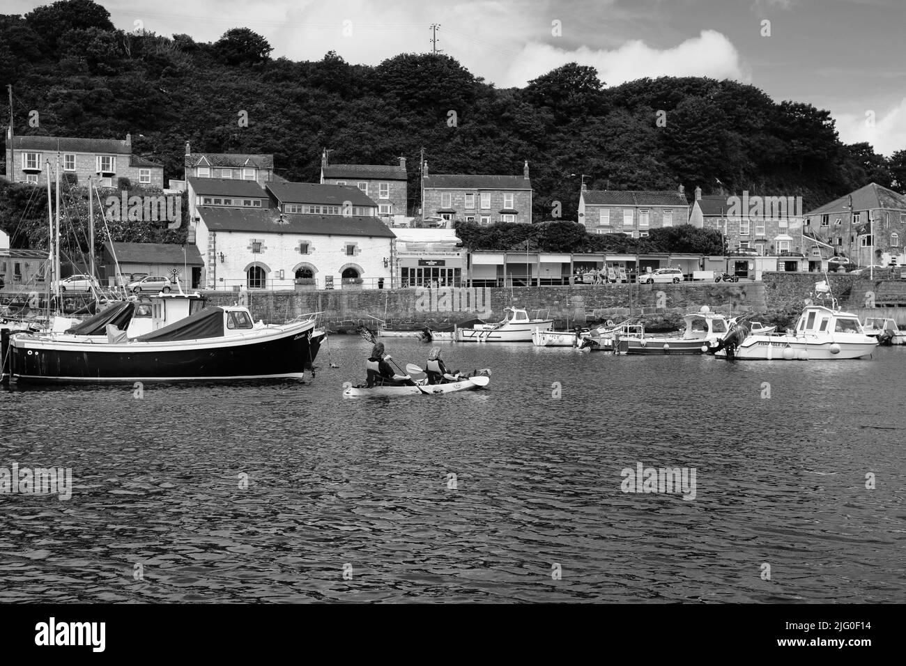 Tourists enjoying kayaking in the inner harbour at Porthleven, Cornwall Stock Photo